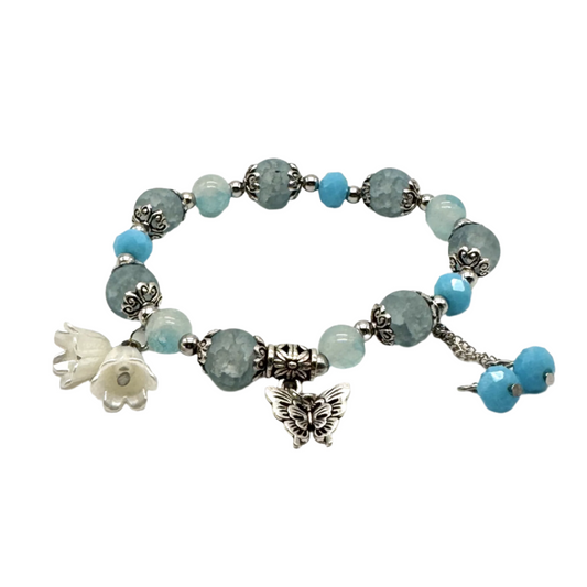 Teal kralen stretch armband met zilveren spacers en vlinder bedel